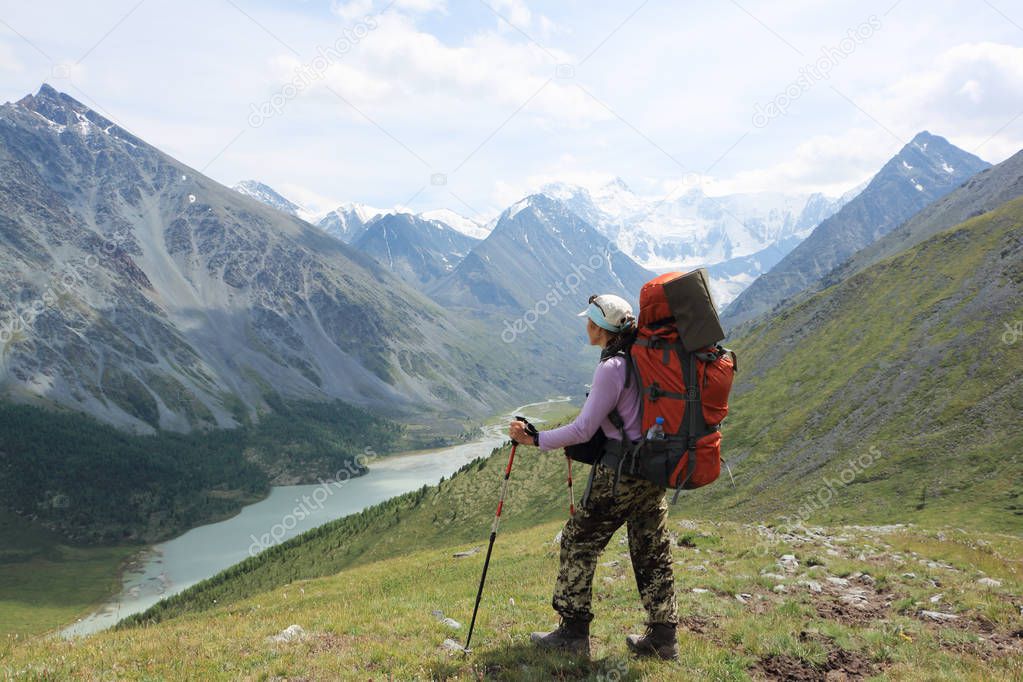 Tourist woman standing on Pass Kara-Turek against the Belukha Mountain and Akkem Lake, Altai, Russia