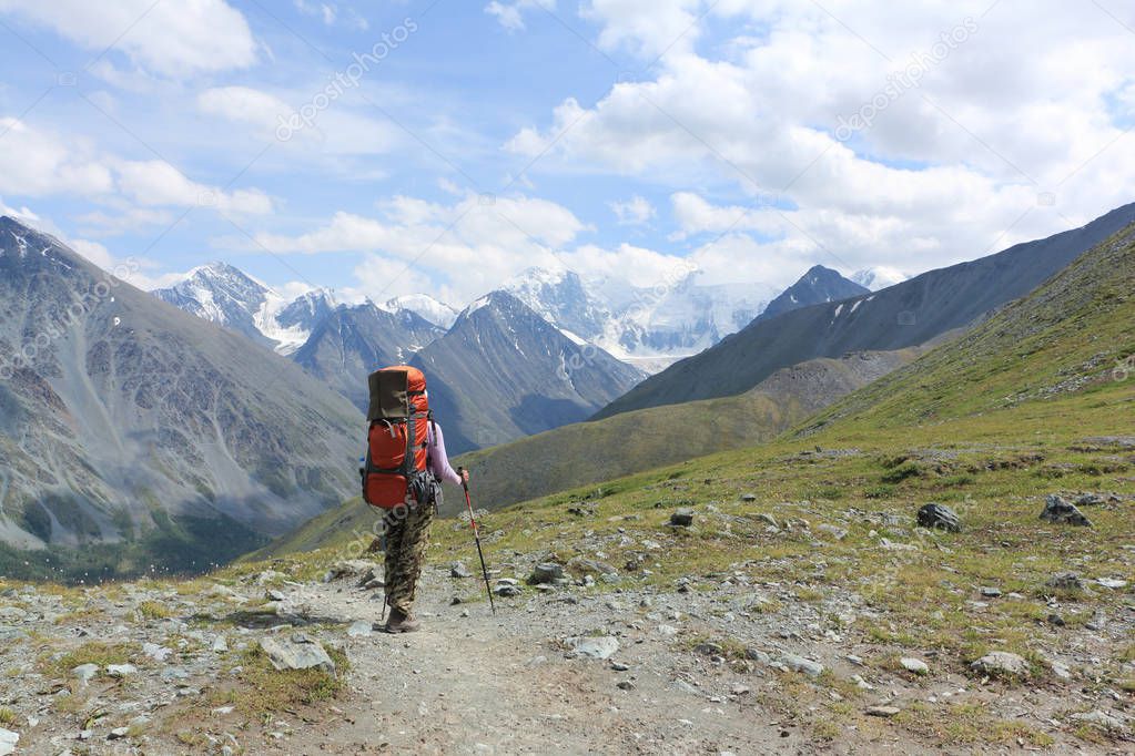 Tourist woman standing on Pass Kara-Turek against the Belukha Mountain, Altai, Russia