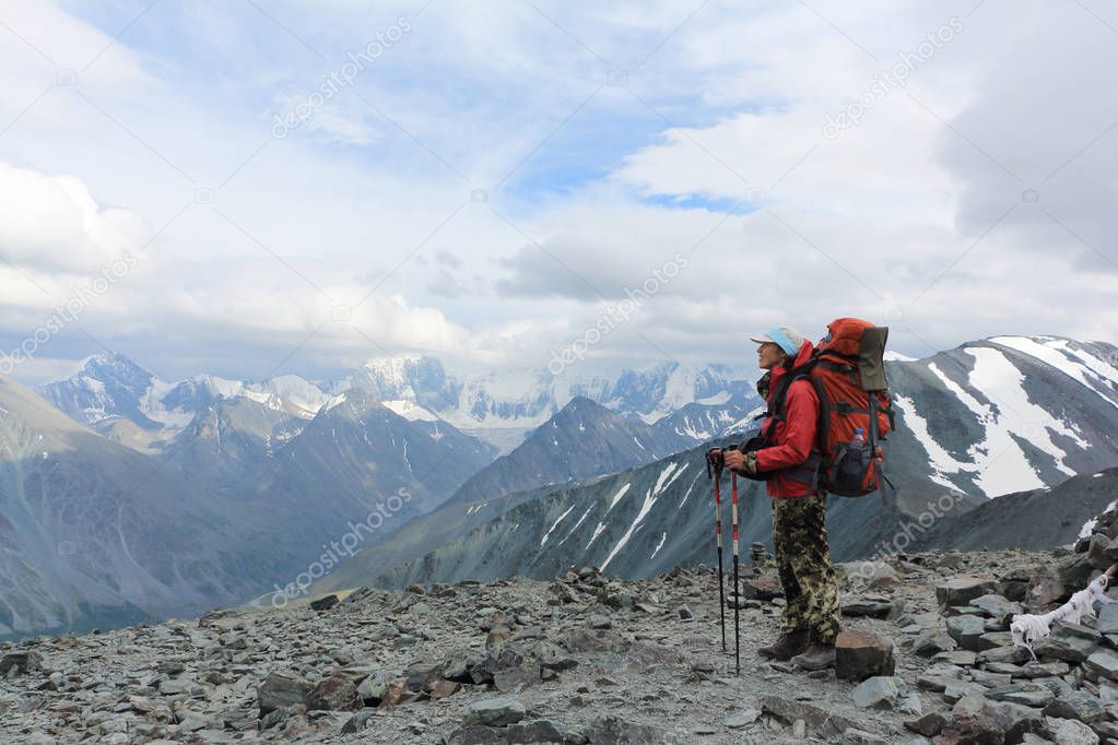 Tourist woman standing on top of the Pass Kara-Turek, against the Belukha Mountain, Altai, Russia