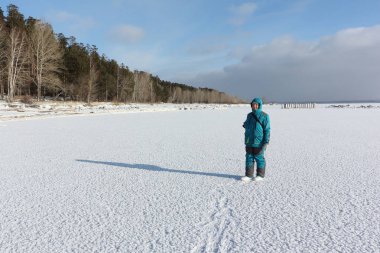 Kadın sıcak giysiler bir donmuş nehir, Ob depo, Rusya karlı yüzeyi boyunca yürüyüş