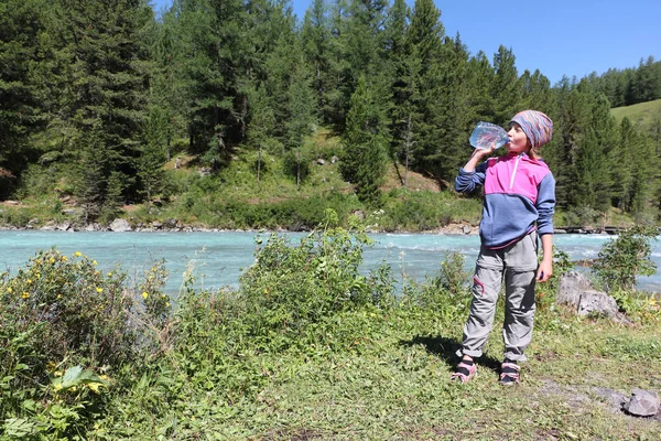 Turysta Dziewczyna Pije Wodę Butelki Tworzyw Sztucznych Pobliżu Górskiej Rzeki — Zdjęcie stockowe