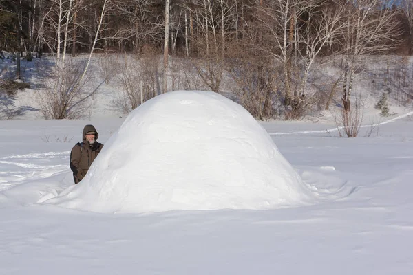 俄罗斯西伯利亚 身穿暖和衣服的男子坐在冰屋边的林间空地上 — 图库照片