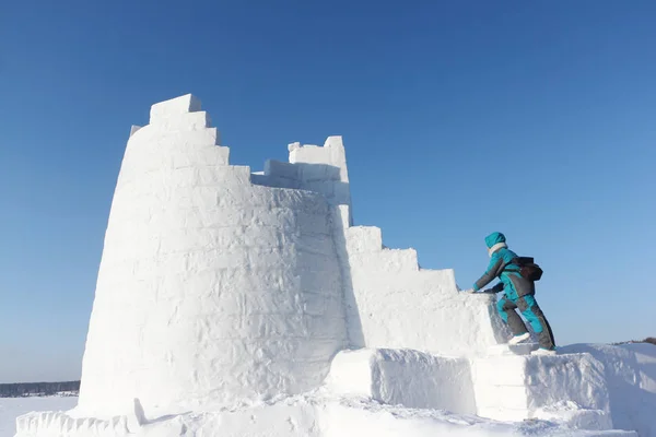 Woman climbing up the steps of a snow tower, Novosibirsk, Russia