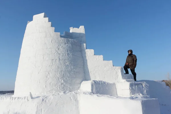 Man climbing up the steps of a snow tower, Novosibirsk, Russia