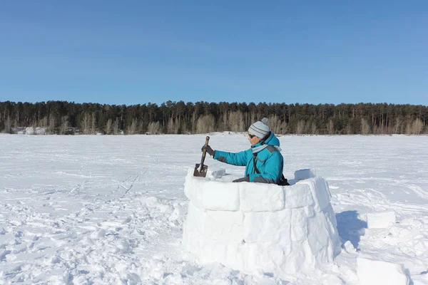 Mulher feliz em roupas quentes construindo um iglu em uma clareira de neve — Fotografia de Stock