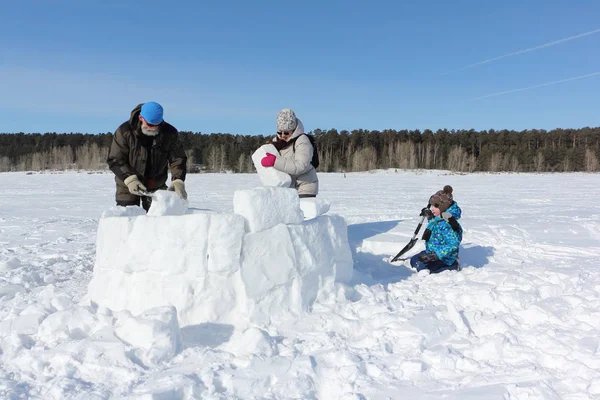 Heureux grand-père, grand-mère et petit-fils construisant un igloo — Photo