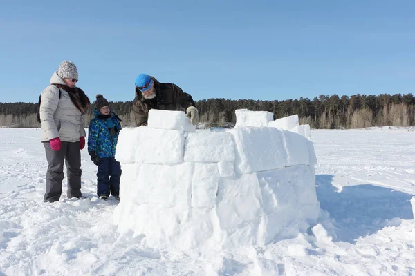 Heureux grand-père, grand-mère et petit-fils construisant un igloo — Photo