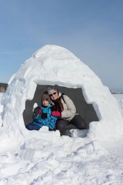 Mutlu büyükanne ve torunu bir igloo oturan 