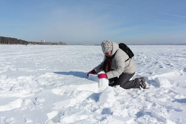 Eskimo evi yapmak için kar bloğu kaldıran kadın.