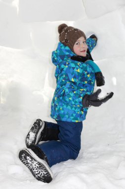 Mutlu neşeli çocuk kışın bir igloo oturan
