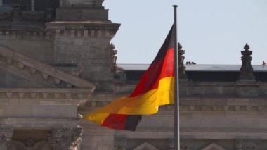 Reichstag Binası Berlin Alman ulusal bayrak mavi bir gökyüzü altında.