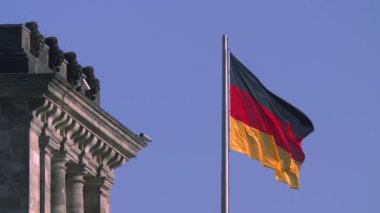 Reichstag Binası Berlin Alman ulusal bayrak mavi bir gökyüzü altında.