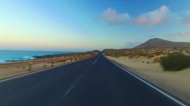 Corralejo, Fuerteventura / İspanya 'daki Ulusal Park' ın kıyı şeridi boyunca giderken, arabaya bir el kol takıldı. Sürücü, post prodüksiyonda tek bir klipte sorunsuz bir şekilde monte edilebilen çeşitli bölümlere bölündü.. 