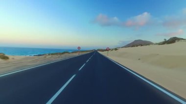 Corralejo, Fuerteventura / İspanya 'daki Ulusal Park' ın kıyı şeridi boyunca giderken, arabaya bir el kol takıldı. Sürücü, post prodüksiyonda tek bir klipte sorunsuz bir şekilde monte edilebilen çeşitli bölümlere bölündü.. 