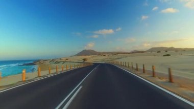 Corralejo, Fuerteventura / İspanya 'daki Ulusal Park' ın kıyı şeridi boyunca giderken, arabaya bir el kol takıldı. Sürücü, post prodüksiyonda tek bir klipte sorunsuz bir şekilde monte edilebilen çeşitli bölümlere bölündü.. 