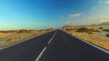 Corralejo, Fuerteventura / İspanya 'daki Ulusal Park' ın kıyı şeridi boyunca giderken, arabaya bir el kol takıldı. Sürücü, post prodüksiyonda tek bir klipte sorunsuz bir şekilde monte edilebilen çeşitli bölümlere bölündü.. 