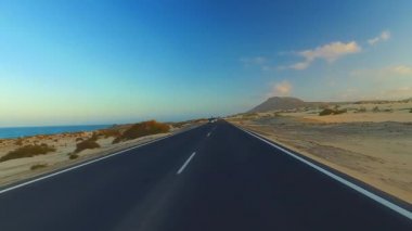 Corralejo, Fuerteventura / İspanya 'daki Ulusal Park' ın kıyı şeridi boyunca giderken, arabaya bir el kol takıldı. Sürücü, post prodüksiyonda tek bir klipte sorunsuz bir şekilde monte edilebilen çeşitli bölümlere bölündü.. 