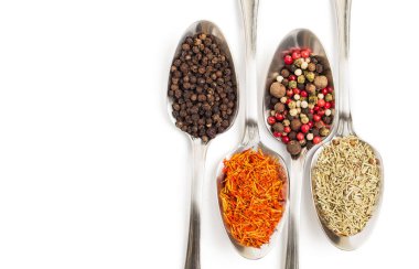 Beyaz arka plan üzerinde izole demir kaşıkları içinde farklı baharatlar. Kurutulmuş biberiye, safran üstten görüntülemek, biber. 