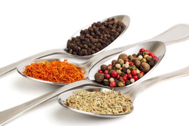 Beyaz arka plan üzerinde izole demir kaşıkları içinde farklı baharatlar. Kurutulmuş biberiye, safran üstten görüntülemek, biber. 