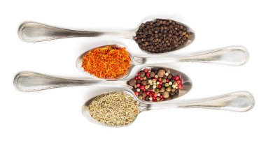 Beyaz arka plan üzerinde izole demir kaşıkları içinde farklı baharatlar. Kurutulmuş biberiye, safran üstten görüntülemek, biber. 