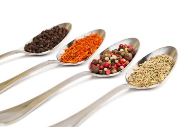Beyaz arka plan üzerinde izole demir kaşıkları içinde farklı baharatlar. Kurutulmuş biberiye, safran üstten görüntülemek, biber. 