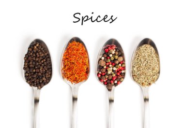 Demir kaşıkları metin baharat beyaz zemin üzerine izole içinde farklı baharatlar. Kurutulmuş biberiye, safran üstten görüntülemek, biber. 