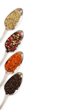 Beyaz arka plan üzerinde izole demir kaşıkları içinde farklı baharatlar. Kurutulmuş biberiye, safran üstten görüntülemek, biber. 