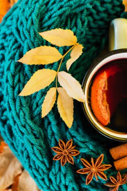 Sonbahar, sonbahar yaprakları, ışıltı şarap bardak ve sıcak bir eşarp mavi ahşap masa arka plan üzerinde dumanı tüten sıcak. Mevsimsel, Sonbahar sıcak şarap, sonbahar rahatlatıcı ve natürmort kavramı. Üstten görünüm