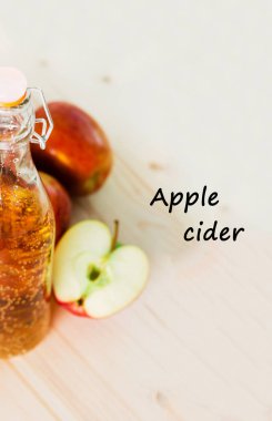 Bir şişe taze elma suyu ve sonbahar elma yakınındaki yarım elma. Ahşap arka plan, metin elma, görüntülemek yukarıdan.