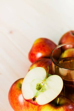 Bardak taze elma suyu ve sonbahar elma yakınındaki yarım elma. Ahşap arka plan, yukarıdan, metin için yer görünümü.