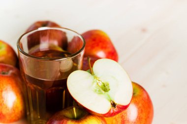 Bardak taze elma suyu ve sonbahar elma yakınındaki yarım elma. Ahşap arka plan, metin için yer. Arka plan.