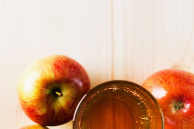 Bardak taze elma suyu ve sonbahar elma yakınındaki yarım elma. Ahşap arka plan, yukarıdan, metin için yer görünümü.