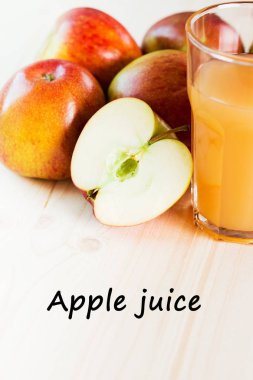 Bardak taze elma suyu ve sonbahar elma yakınındaki yarım elma. Ahşap arka plan, metin elma suyu.