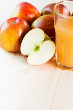 Bardak taze elma suyu ve sonbahar elma yakınındaki yarım elma. Ahşap arka plan, metin için yer. Arka plan.