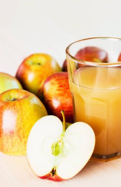 Bardak taze elma suyu ve sonbahar elma yakınındaki yarım elma. Ahşap arka plan, metin için yer. Arka plan.