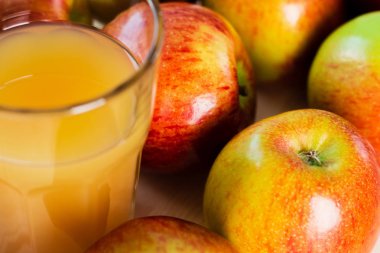 Yakın çekim bardak taze elma suyu sonbahar elma yakınındaki bir bakış. Ahşap arka plan, yukarıdan görünüm.