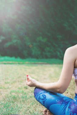 Genç kadın doğada Yoga uygulamak. Yeşil çimenlerin üzerinde oturan ve meditasyon. Yeşil renkli tonda etkisi ile. Sağlıklı ve spor kavram. Metin için yer kopyalayın.