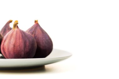 Beyaz arka plan üzerinde izole gri plaka üzerinde taze incir. Metin için yer kopyalayın