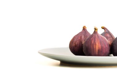 Beyaz arka plan üzerinde izole gri plaka üzerinde taze incir. Metin için yer kopyalayın