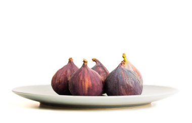 Beyaz arka plan üzerinde izole gri plaka üzerinde taze incir. Metin için yer kopyalayın