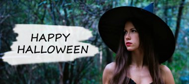 Cadılar Bayramı tatil arka plan. Karanlık bir ormanda halloween cadı. Güzel genç kadın cadı şapka ve metin kostüm Cadılar Bayramın kutlu olsun.