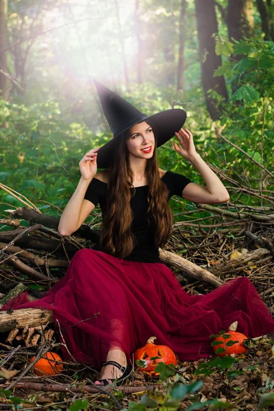 ハロウィーンの休日背景 ハロウィン魔女トーン効果と暗い森で変な顔とハロウィーン カボチャのジャック ランタン装飾が施されました 魔女帽子と衣装の美しい若い女性 — ストック写真