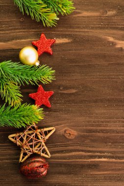Noel ve yeni yıl gün dekorasyon, topları, çam dalları, kırmızı yıldızlar ve ahşap yıldız ahşap arka plan üzerinde. Düz yatıyordu. Yukarıdan görüntüleyin. Metin için yer kopyalayın.