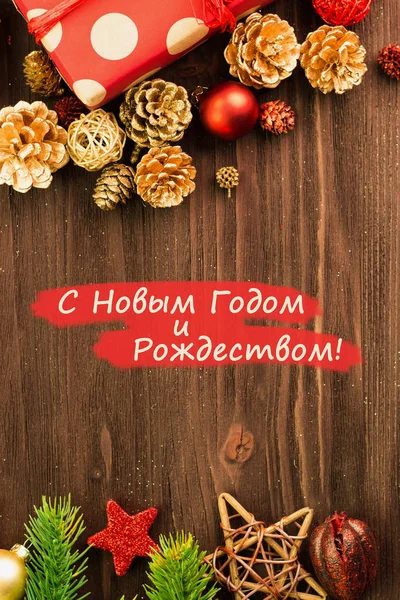 ボール Fir コーン 枝およびテキスト メリー クリスマスと新年あけましておめでとうございます ロシア語で翻訳 木材の背景に金色の円を持つ存在に包まれた赤い紙が付いている星 フラットが横たわっていた コピーのテキストのための領域 — ストック写真