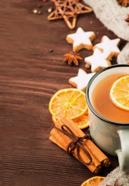 Kış ve yılbaşı tema. Noel çay baharat, çay portakal, tarçın, anason, yıldız, biber ve ahşap arka plan üzerinde gri eşarp şeklinde kurabiye ile. Metin için yer kopyalayın. Yukarıdan görüntülemek.