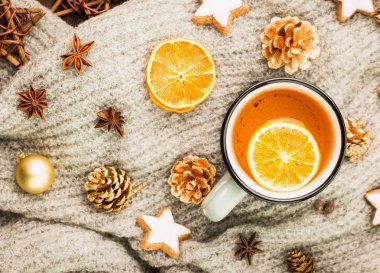 Kış ve yılbaşı tema. Baharat ile Noel çay, portakal, tarçın, anason, yıldız, köknar koni şeklinde kurabiye ile çay biber üzerinde gri eşarp. Yat, yukarıdan görüntüleme. 