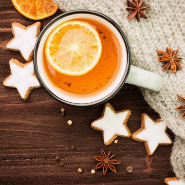 Kış Tema. Noel çay baharat, çay portakal, tarçın, anason, yıldız, biber ve ahşap arka plan üzerinde gri eşarp şeklinde kurabiye ile. Yat, yukarıdan görüntüleyin. Metin için yer kopyalayın.