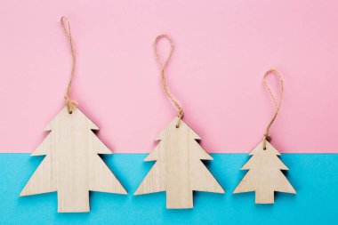 Noel ve yeni yıl gün festival dekorasyon, mavi ve pembe arka plan üzerinde ahşap Noel ağaçları. Metin için yer kopyalayın. Düz yatıyordu. Yukarıdan görüntülemek.