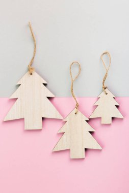 Noel ve yeni yıl gün festival dekorasyon, ahşap Noel ağaçları pembe ve gri arka plan üzerinde. Metin için yer kopyalayın. Düz yatıyordu. Yukarıdan görüntülemek.
