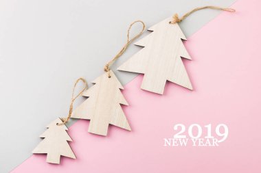 Noel ve yeni yıl gün festival dekorasyon, ahşap Noel ağacı pembe ve gri arka plan üzerinde. Metin için yer kopyalayın. Düz yatıyordu. Gelen yukarıdaki metin ile 2019 yeni yıl görüntülemek.